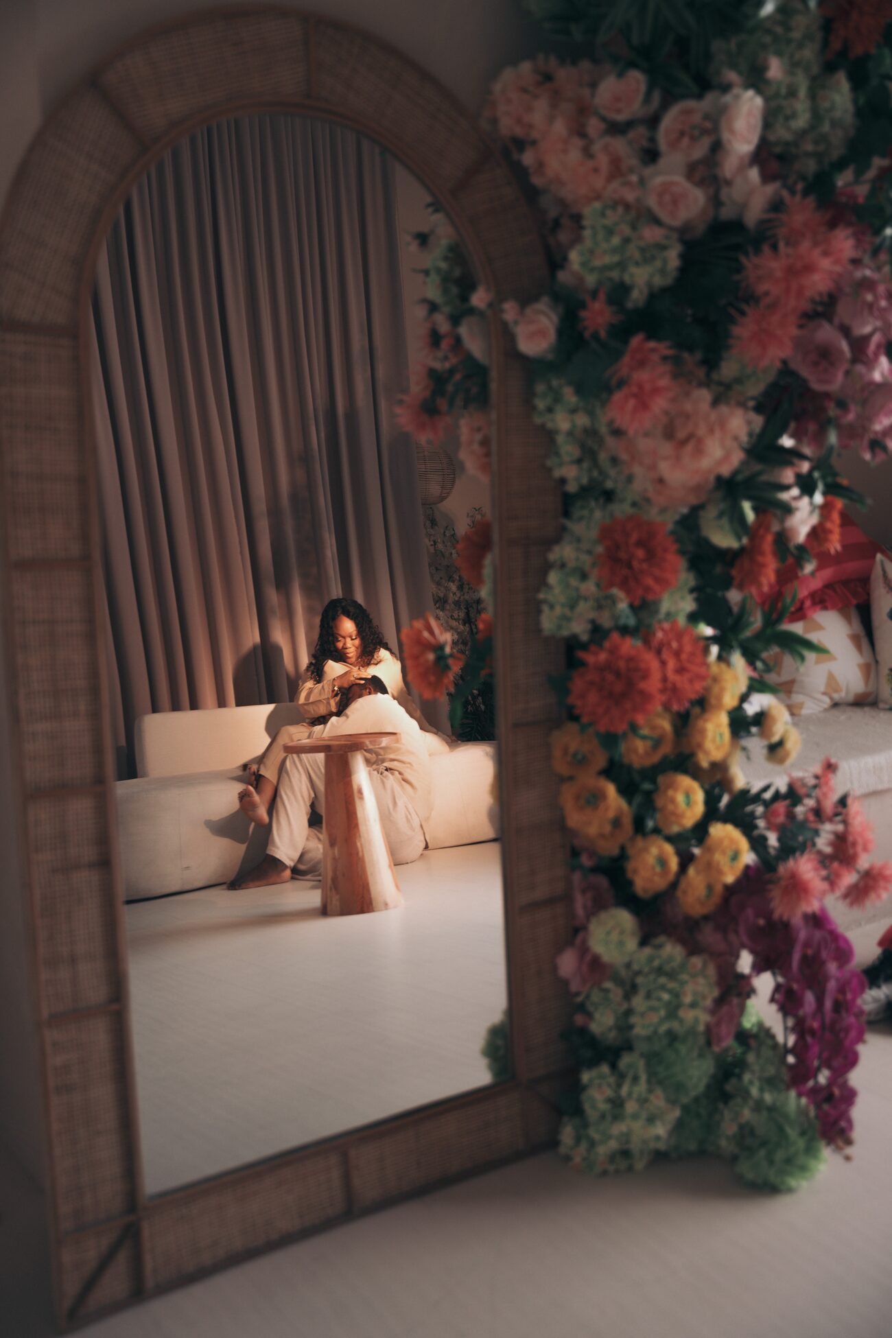 Expectant mother seated inside a floral archway