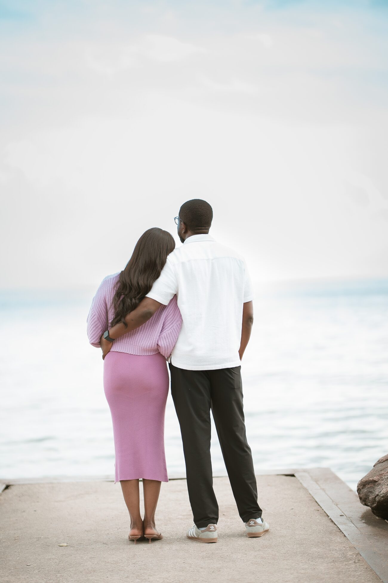 Couple standing at the water's edge looking out over the lake