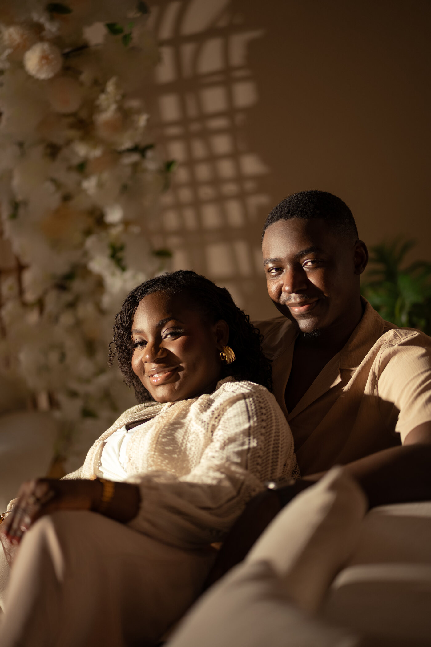 Expectant couple seated together in warm light